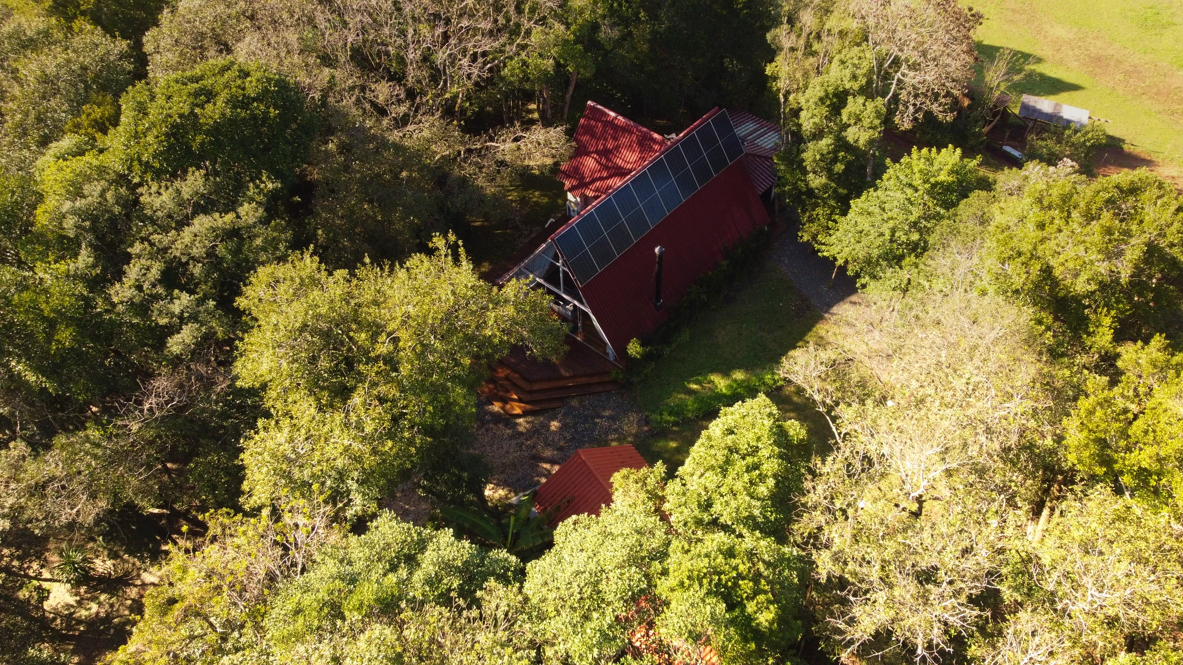 Chalé integrado à mata visto por drone